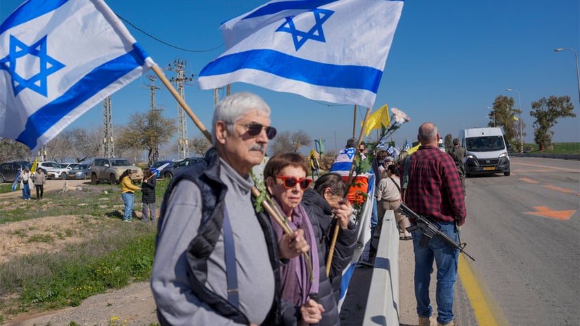 Israelis line the highway during a funeral procession.