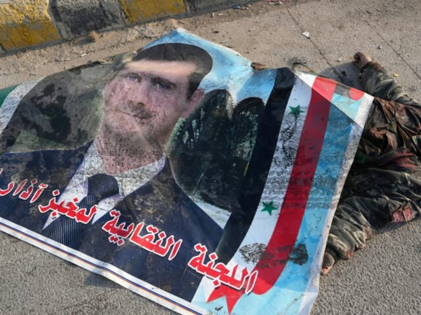 EDITORS NOTE: Graphic content / The body of a killed Syrian army soldier is covered with a