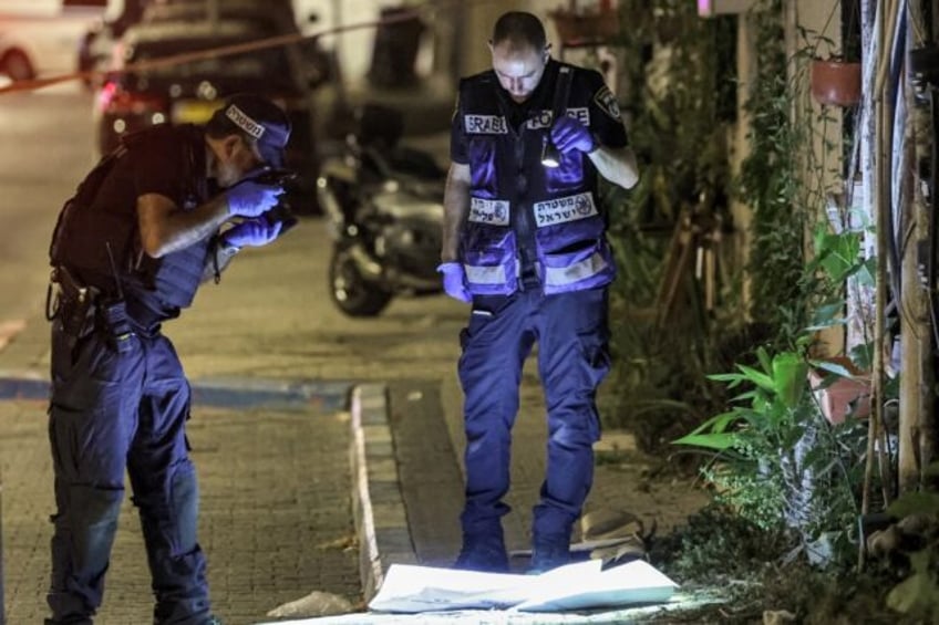 Police forensics experts examine the scene of the deadly knife and gun attack in the Jaffa