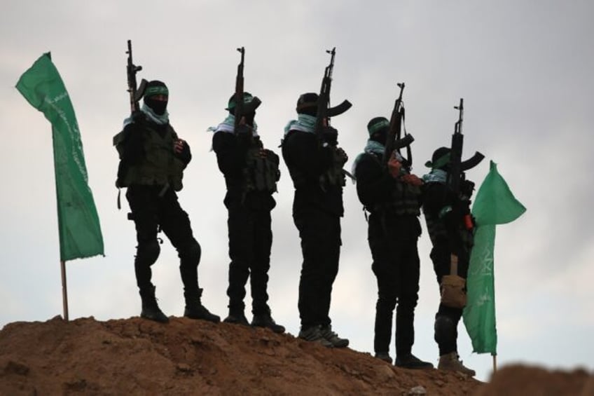 Palestinian Hamas militants gather at the site of the handover of four Israeli hostages' b