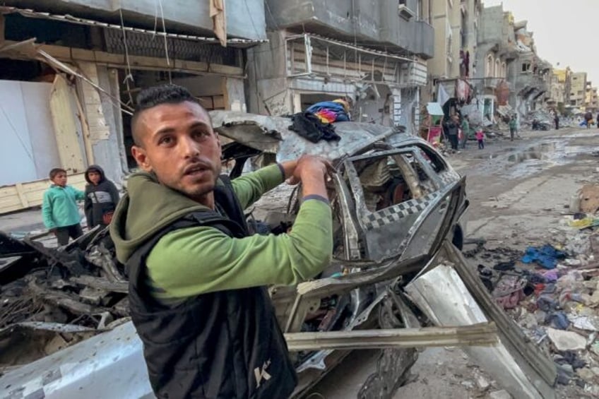 A man gestures in front of the car in which three sons of Hamas leader Ismail Haniyeh were