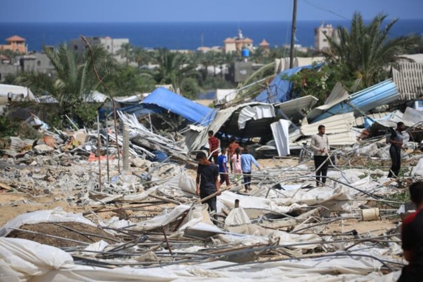 People look for salvageable items following an Israeli raid in southern Gaza's Al-Mawasi a