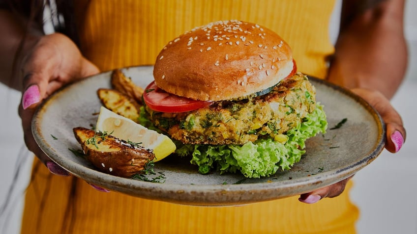 a woman holding a veggie burger