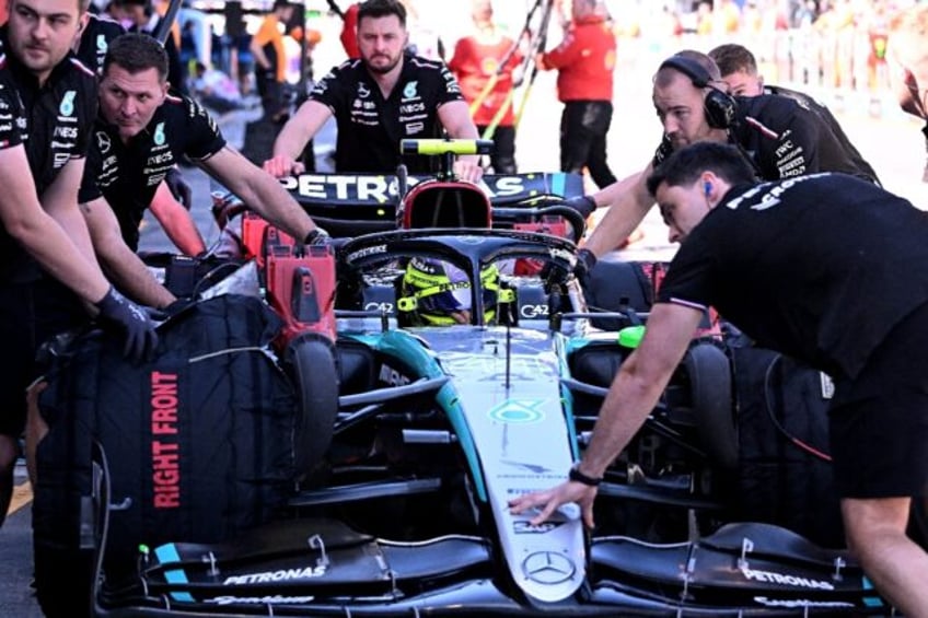 Mechanics get Mercedes' driver Lewis Hamilton's car ready in Melbourne