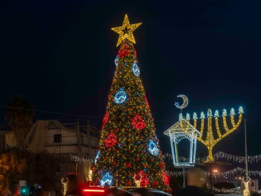 People celebrate with Christmas decorations in Haifa, Israel, Monday, Dec. 23, 2024. (AP P