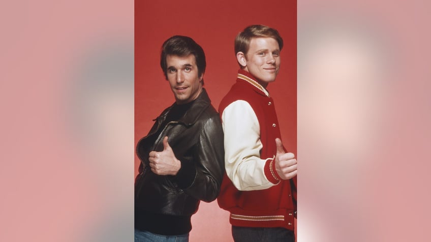 A close-up of Henry Winkler and Ron Howard in costume giving their thumbs up