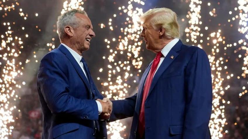 RFK and Trump shaking hands on stands with fireworks behind them