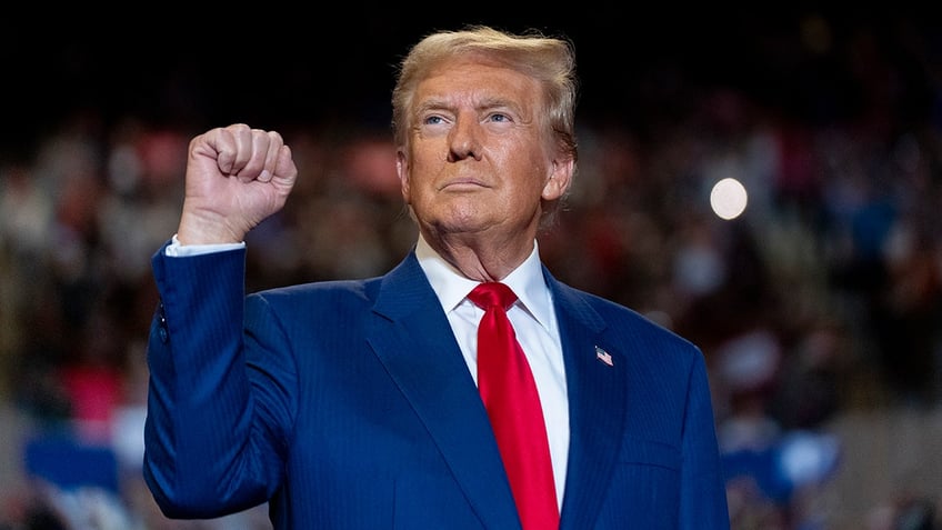 Donald Trump in blue suit, pumping fist