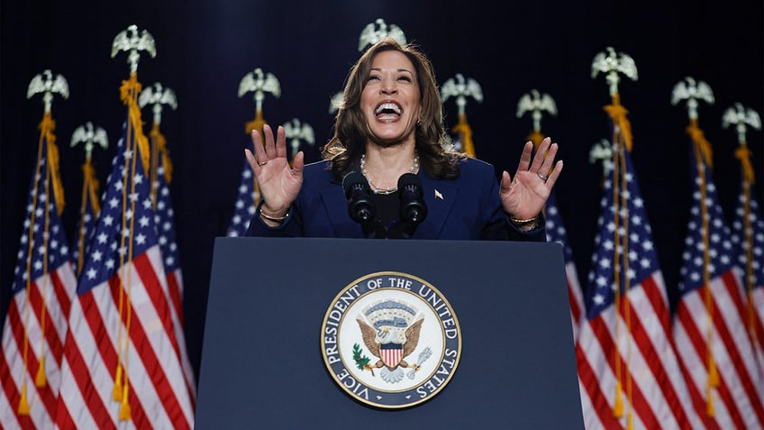 Kamala Harris with US flags behind her at rally