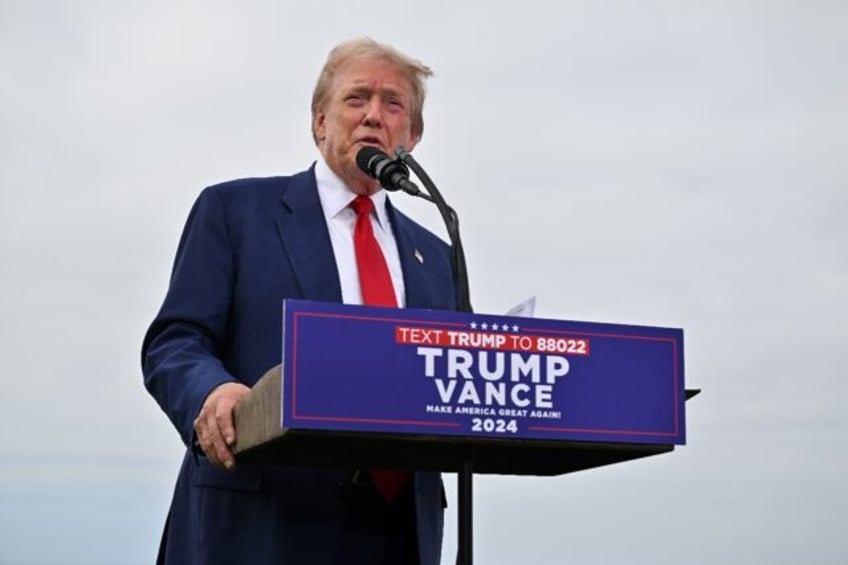 Donald Trump talks to reporters at his golf course outside Los Angeles ahead of a rally in