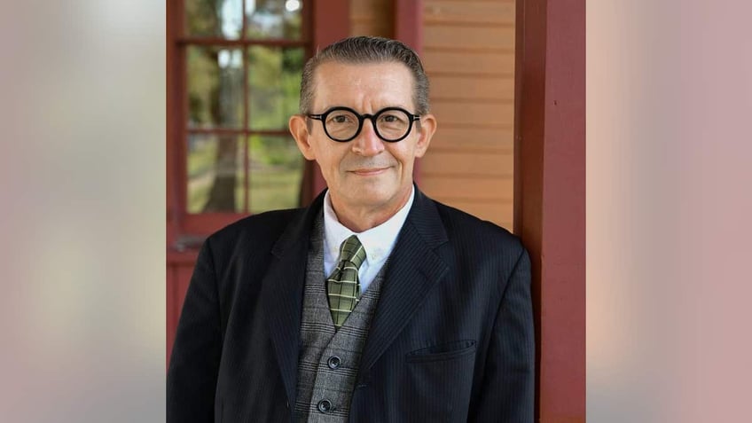 Man wears black-rimmed glasses.