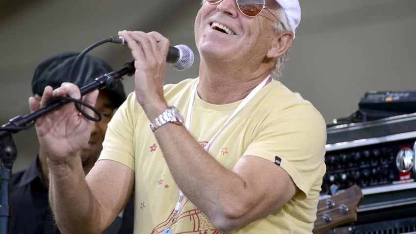 jimmy buffett smling and performing