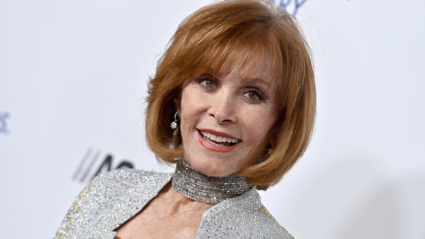 A close-up of Stefanie Powers wearing a silver dress.