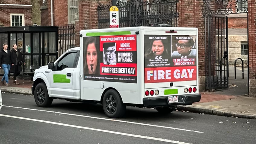 closeup shot of box truck with "fire gay" placards