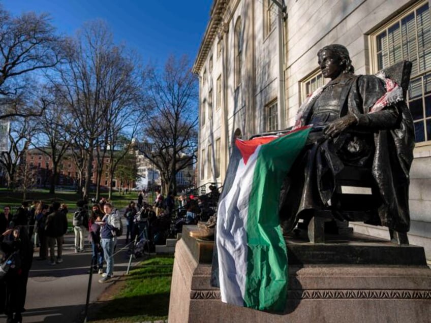 Students protesting against the war in Gaza, and passersby walking through Harvard Yard, a