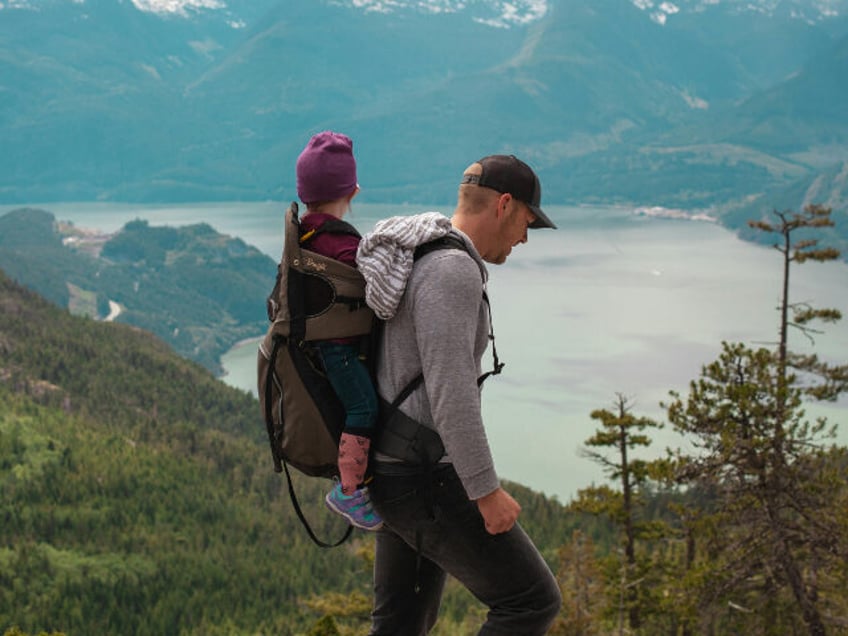 Man with child in backpack hiking