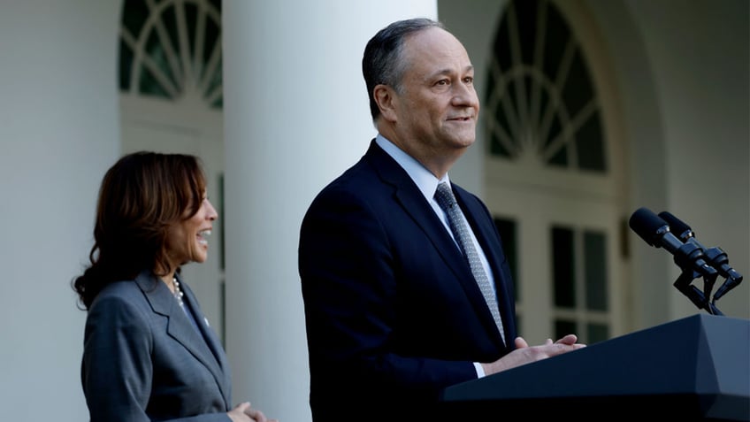 Doug Emhoff speaking with Kamala Harris behind him