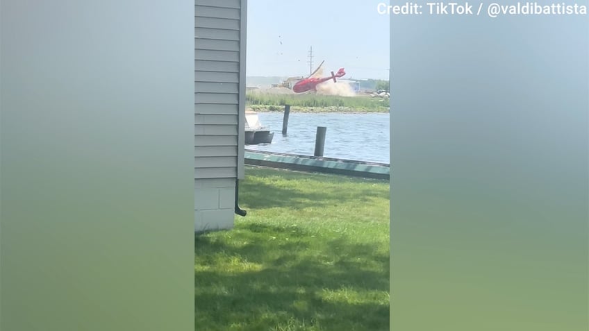 A red helicopter was seen hovering over land before crashing near a Michigan restaurant on Sunday.