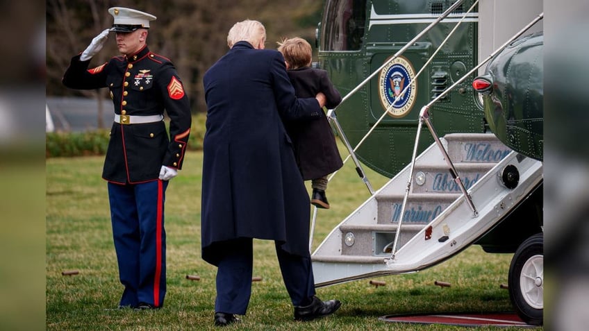 President Donald Trump lifts Elon Musk's son, "Lil X," onto the steps of Marine Force One