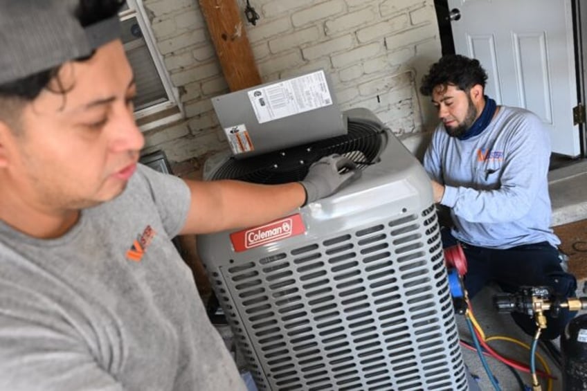 Technicians install a heat pump that replaces the furnace and air conditioner at Su Balasu