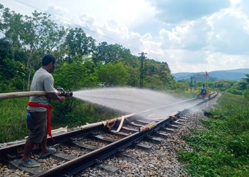 Thai railway workers doused the melting tracks with water to try to bend them back into sh