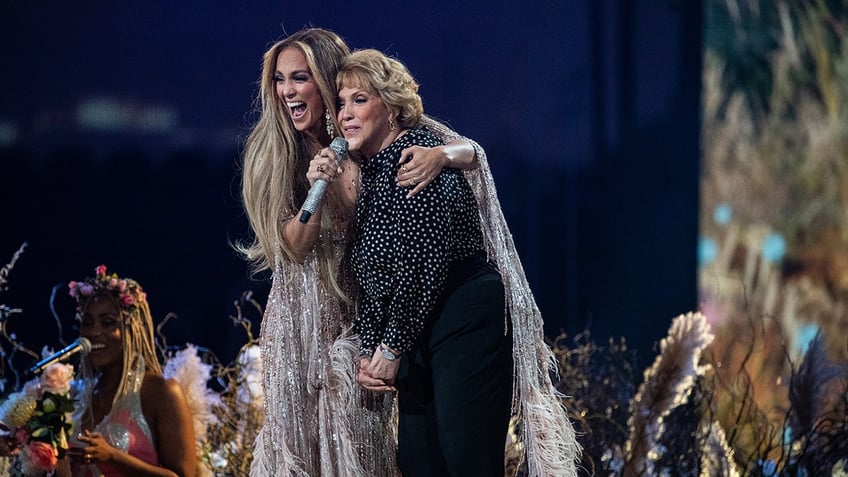 Jennifer Lopez with her arm around her mom Guadalupe on stage