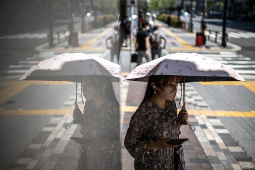 Some Tokyo residents carry parasols to beat the heat