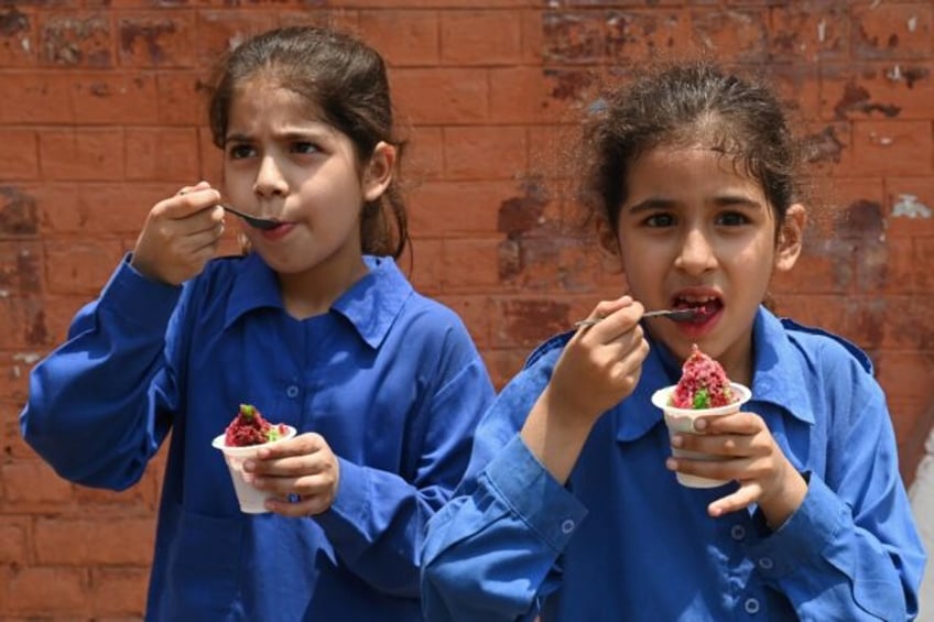 Students eat ice cream outside their school in Lahore, the capital city of Pakistan's Punj