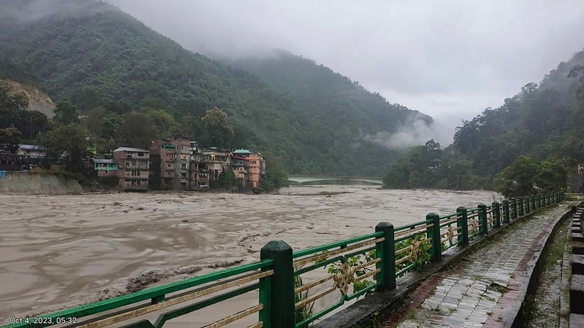 heavy rainfall triggers sudden flooding in northeastern india resulting in fatalities and submerging towns