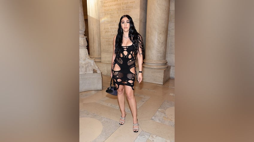 Lourdes Leon in a black dress with many cutouts.