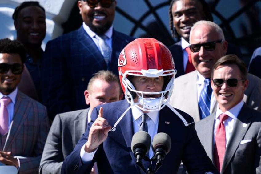 US President Joe Biden wears a Kansas City Chiefs helmet while speaking during a celebrati