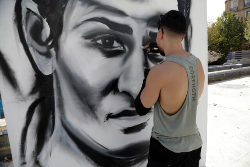 An artist paints a large portrait of Algerian Olympic boxing champion Imane Khelif in her