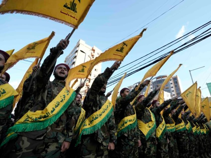 Hezbollah members march during the funeral procession of their comrades who were killed in