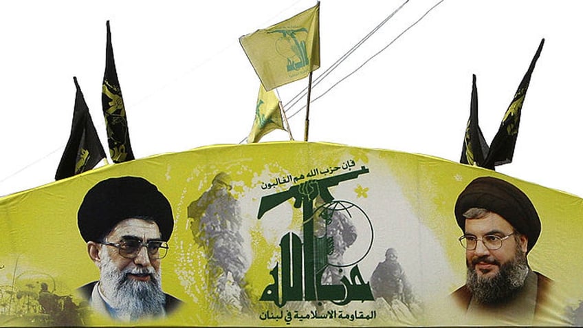 An arch glorifying Hezbollah and baring pictures of its chief Hassan Nasrallah (R) and Iran's spiritual leader Ali Khamenei decorates a street of Beirut's southern subburb on January 16, 2011.  Draft charges implicating Hezbollah in the 2005 murder of Lebanese premier Rafiq Hariri are likely to be presented under wraps to the Special Tribunal for Lebanon on January 17, 2011. AFP PHOTO/ANWAR AMRO (Photo credit should read ANWAR AMRO/AFP via Getty Images)