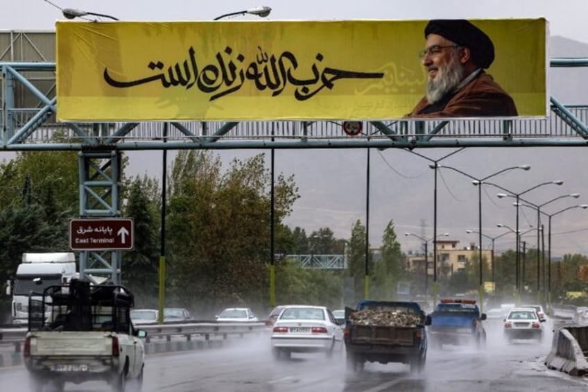 A picture of Hezbollah leader Hassan Nasrallah reads in Farsi, 'Hezbollah is alive', in no