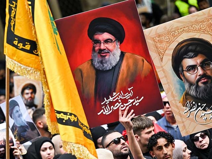 Demonstrators hold flags and pictures of Hassan Nasrallah, late leader of the Lebanese gro