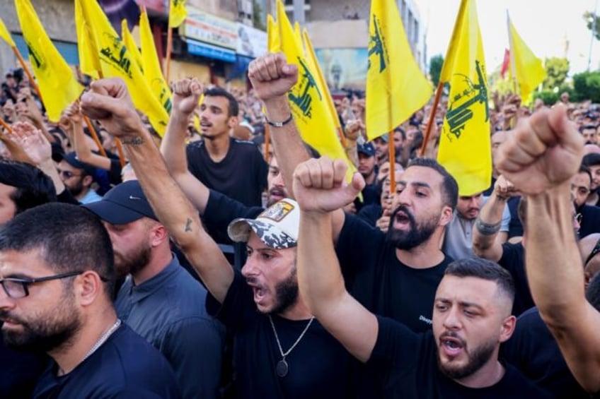 Mourners, some waving Hezbollah flags, attend the funeral of group members killed in an Is