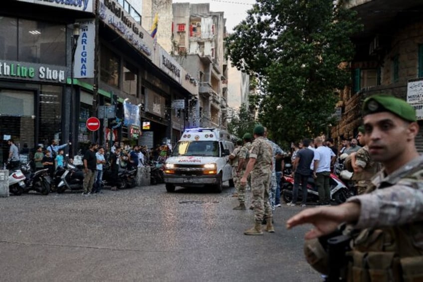 Lebanese soldiers stand guard as an ambulance rushes wounded people to hospital in Beirut