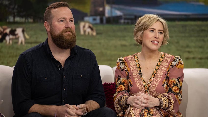 erin and ben napier sititng on a couch looking off to the side