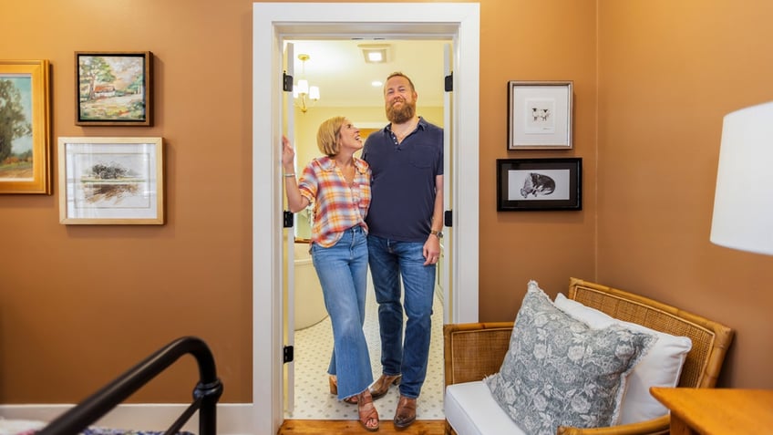 Erin and Ben Napier pose in a remodeled home