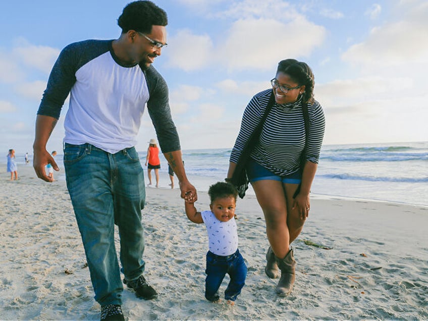 family with man and and woman and child on the beach