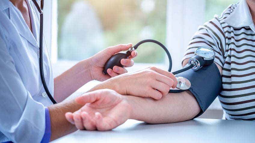 Doctor measures the blood pressure of the patient during a medical examination