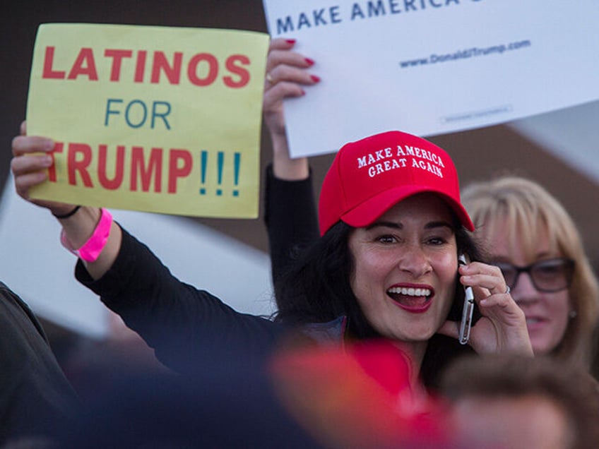 A woman hoods a sign expressing Latino support for Republican presidential candidate Donald Trump at his campaign rally at the Orange County Fair and Event Center, April 28, 2016, in Costa Mesa, California. - Trump is vying for votes in the June 7 California primary election in hope of narrowing …