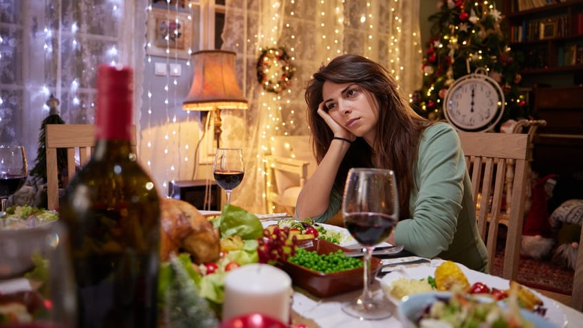 woman thinking alone on Christmas at dining table