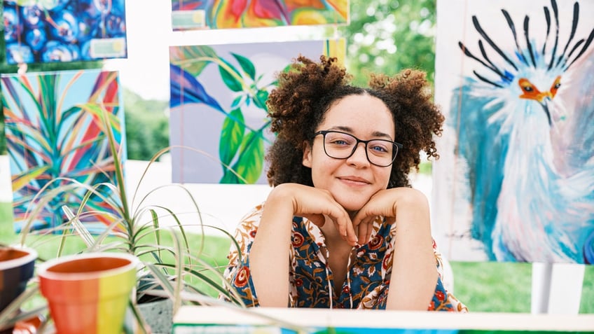 An artist surrounded by her artwork