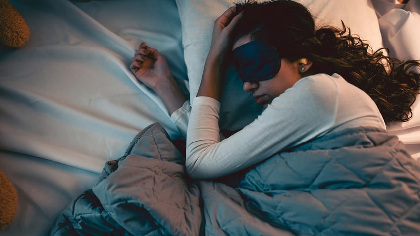 woman sleeps with sleep mask