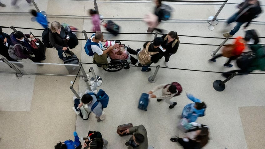 Travelers wait to go through security at San Francisco International Airport (SFO) in San Francisco, California, US, on Monday, Dec. 23, 2024. The Transportation Security Administration (TSA) anticipates screening 40 million passengers this holiday season.