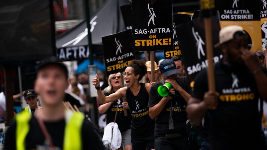 Protestors carrying SAG-AFTRA strike signs