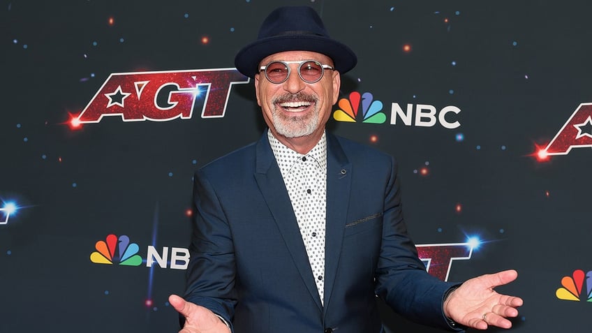 Howie Mandel smiling and posing on the red carpet