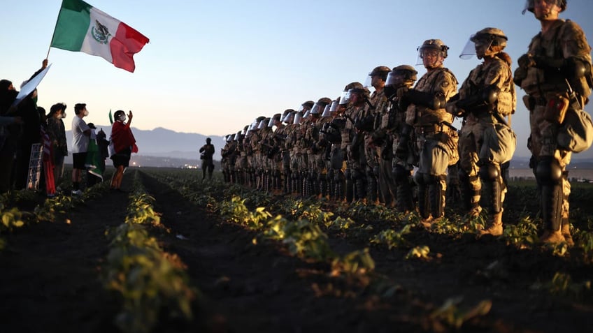 National Guard troops block protesters from an ICE raid at a nearby cannabis farm in California.